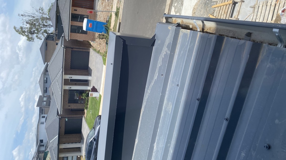 Parapet wall capping fixed from the top, recorded on a handover inspection in Austral